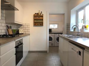 a kitchen with a sink and a washing machine at House with parking, short stroll to Quay, shops and restaurants in Poole