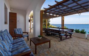 a patio with a table and benches and the ocean at 4 Bedroom Stunning Home In Jablanac in Jablanac