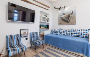 a bedroom with a blue bed and two chairs at 4 Bedroom Stunning Home In Jablanac in Jablanac