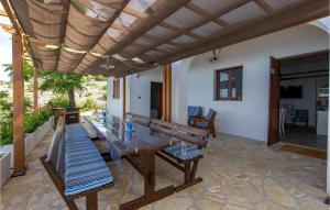 a patio with a wooden table and benches at 4 Bedroom Stunning Home In Jablanac in Jablanac