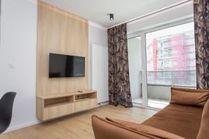 - un salon avec un canapé et une télévision dans l'établissement Urban Jungle apartament Emily, à Białystok