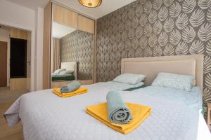 a bedroom with two beds with towels on them at Urban Jungle apartament Emily in Białystok