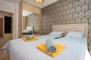 sypialnia z 2 łóżkami i ręcznikami w obiekcie Urban Jungle apartament Emily w mieście Białystok