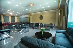 un restaurante con sofás, mesas y sillas en Pearl Resort & Hotel, en Nonthaburi