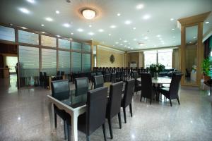 a dining room with tables and chairs in a building at Pearl Resort & Hotel in Nonthaburi