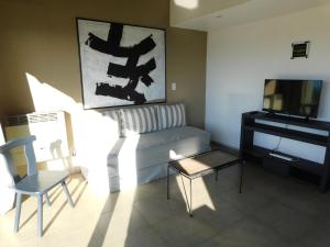 a living room with a couch and a television at MI CASA TU CASA in El Calafate