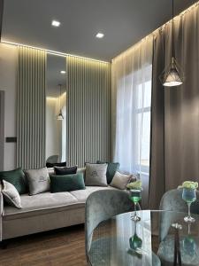 a living room with a couch and a glass table at Central Family Boutique Apartments 3 in Lviv