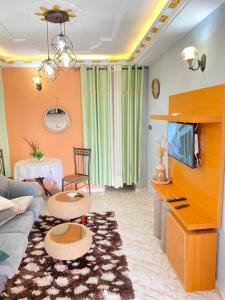a living room with a couch and a tv at N-E Studio meublé 2 in Douala