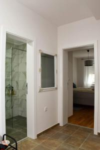 bagno con doccia e porta in vetro di Apartman Harmony a Sombor