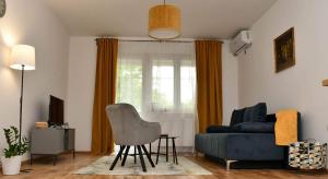 a living room with a couch and a chair at Apartman Harmony in Sombor