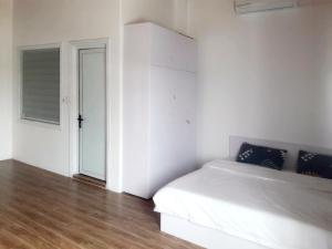 biała sypialnia z łóżkiem i drzwiami w obiekcie Hồng Dương Villa Homestay - phòng đôi view sông Hương trung tâm thành phố #101 w mieście Hue