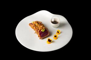 a white plate with a piece of cake and a glass of milk at Resort Miramonti in Forte dei Marmi