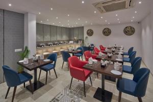 a restaurant with tables and chairs and a kitchen at Regenta Inn 4th Block Koramangala Bangalore in Bangalore