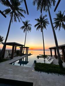 un complexe avec une piscine, des palmiers et l'océan dans l'établissement Villa Hanna Luxury Beachfront Koh Samui, à Koh Samui 