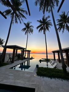 苏梅岛Villa Hanna Luxury Beachfront Koh Samui的拥有游泳池、棕榈树和海洋的度假胜地