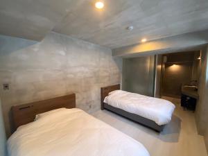 ein Schlafzimmer mit zwei Betten und einem Waschbecken in der Unterkunft maejima Hotel in Naha