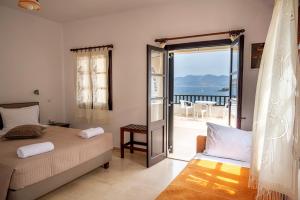 1 dormitorio con cama y vistas al océano en Pelagos Seafront Accommodation - Maria, en Myrties