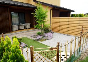 un jardin en face d'une maison avec une clôture dans l'établissement Hananoyado Yumefuji, à Fujikawaguchiko