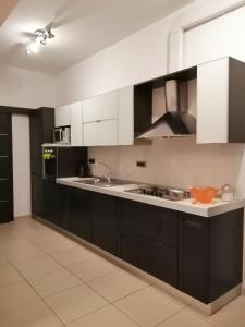 eine Küche mit schwarzen Schränken und weißen Geräten in der Unterkunft Heraclea Home in Roseto Capo Spulico
