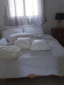 a bed with white sheets and pillows on it at near the sea even 14 days won't feel enough in Tel Aviv