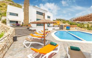 a villa with a swimming pool with chairs and an umbrella at Villa Holivista in Benalmádena