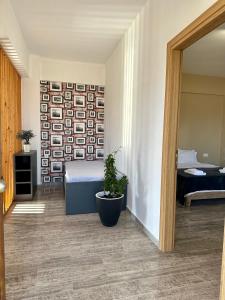 a bedroom with a bed and a potted plant at Nautica Hotel Apartments in Stavromenos