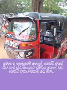 Una furgoneta roja y negra con gente delante. en Chathuni Holiday Home, en Anuradhapura