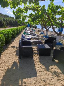a row of lounge chairs on a sandy beach at Bella Vista in Yi&aacute;ltra