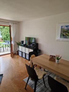 sala de estar con mesa de madera y TV en Ferienwohnung Milan en Oberstaufen