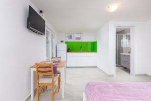 Studio Apartment Mali في ميدولين: مطبخ أبيض مع طاولة ومكتب