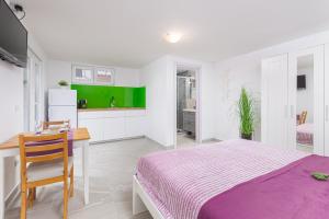 a bedroom with a bed and a desk and a kitchen at Studio Apartment Mali in Medulin