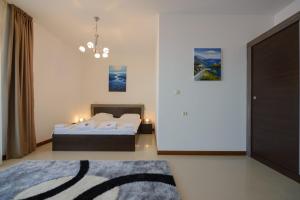 een slaapkamer met 2 bedden en een kroonluchter bij Mia Cassa in Sveti Vlas