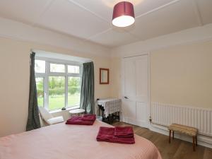 a bedroom with a bed with two red pillows on it at The Anchorage in Shepton Mallet