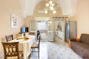 uma cozinha e sala de estar com uma mesa e um sofá em La Casa di Anna em Sava