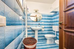 uma casa de banho em azulejos azuis com um WC e um lavatório em La Casa di Anna em Sava