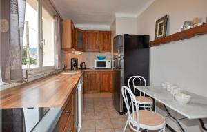 a kitchen with a black refrigerator and a table with chairs at Beautiful Home In Saint-André in Saint-André