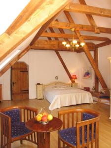 Casa Rozelor في براشوف: غرفة نوم بسرير وطاولة وكراسي