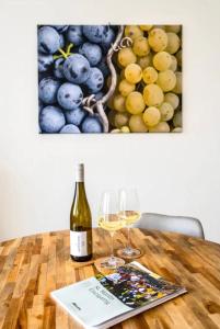 ザンクト・マルティンにあるHaus Sebaldの木製テーブルにワイン1本とグラス2杯