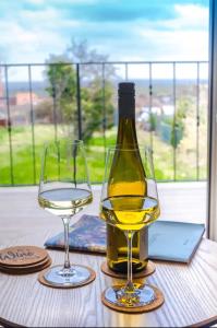 een fles wijn en twee glazen op een tafel bij Haus Sebald in Sankt Martin
