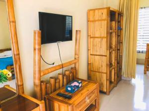 a living room with wooden furniture and a flat screen tv at Tea Heaven Resort in Sreemangal
