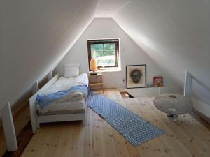 een slaapkamer op zolder met een bed en een raam bij Fishermans Cottage Anno 1861 - Skåre Fiskeläge in Trelleborg