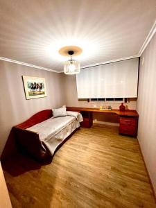 1 dormitorio con cama, mesa y lámpara de araña en ÁTICO RIBEIRA CENTRO, en Ribeira