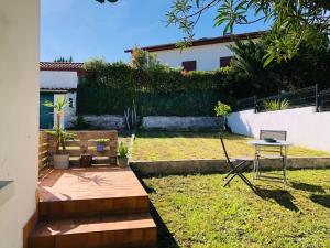 a small yard with a table and a laptop on it at Le petit Erromardie in Saint-Jean-de-Luz
