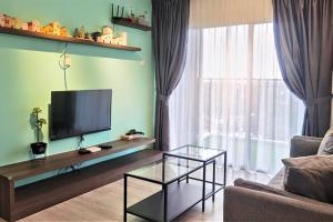 Emerald Avenue Cozy 3R3B Apartment 716 في برينشانغ: غرفة معيشة مع تلفزيون بشاشة مسطحة وأريكة