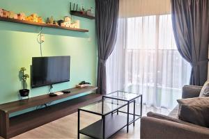 ein Wohnzimmer mit Flachbildfernseher und Couch in der Unterkunft Emerald Avenue Cozy 3R3B Apartment 716 in Brinchang