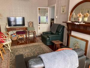 a living room with a couch and a tv at Rose Cottage in Bunbury