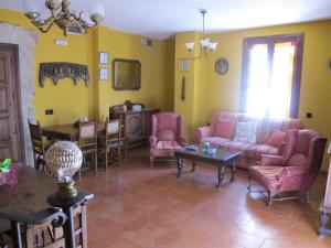 Casa Rural Cuatro de Oros في Santa Cruz de la Zarza: غرفة معيشة بأثاث وردي وطاولة