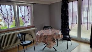 a dining room with a table and chairs and windows at Schöne 2-Zimmer Ferienwohnung in Löffingen