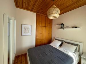 a bedroom with a bed with a wooden ceiling at Emerald in blue in Loutraki