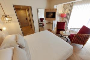 ein Hotelzimmer mit einem weißen Bett und einem Spiegel in der Unterkunft Hotel Onda in Calvi